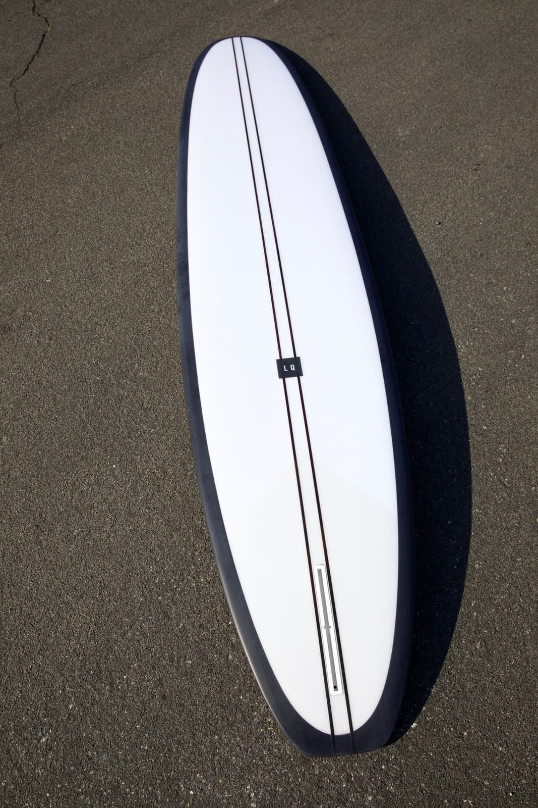 Black Pearl longboard white deck with black rails lifestyle shot